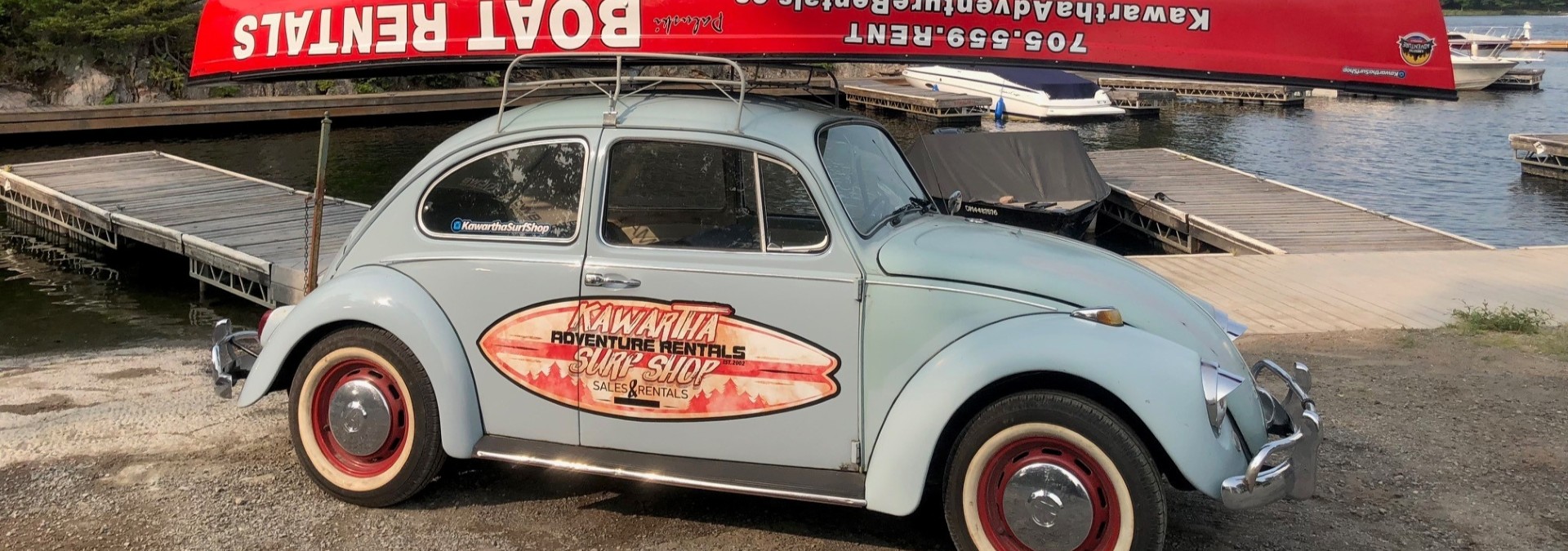 VW Beetle with Kawartha Adventure Rentals logo on the side and canoe on top