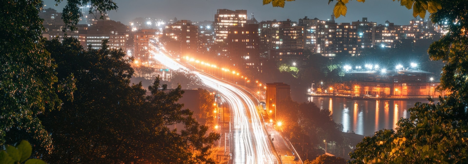 Vehicle light trails on a highway seen from above.